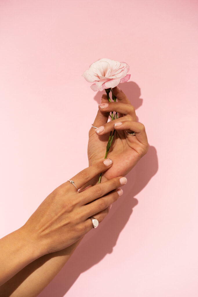 woman showing her nail art fingernails with flower